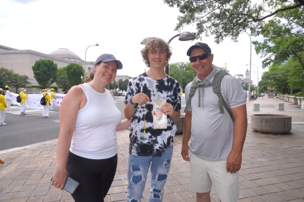 2025年7月17日，来自纽约州首府奥尔巴尼一所公立学校的建筑维护技术员Timothy Call（右）和妻子Ariel、继子Dylan Maxwell观看了法轮功华府大游行。（李辰/大纪元） 