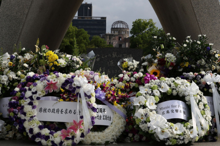 2025年8月5日，广岛和平纪念公园内，民众献上鲜花与和平讯息，背景为原爆圆顶馆。(Buddhika Weerasinghe/Getty Images)