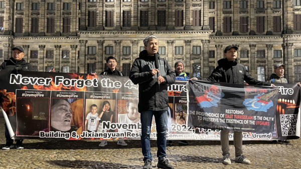 2025年11月23日晚,约10名异议人士来到荷兰阿姆斯特丹水坝广场,纪念乌鲁木齐大火三周年。图为阿不都热依木‧艾尼演讲。(反共之声创办人刘飞龙提供)