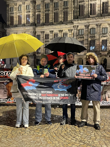 2025年11月23日晚,约10名异议人士来到荷兰阿姆斯特丹水坝广场,纪念乌鲁木齐大火三周年。图为韦智坚发言。(反共之声创办人刘飞龙提供)