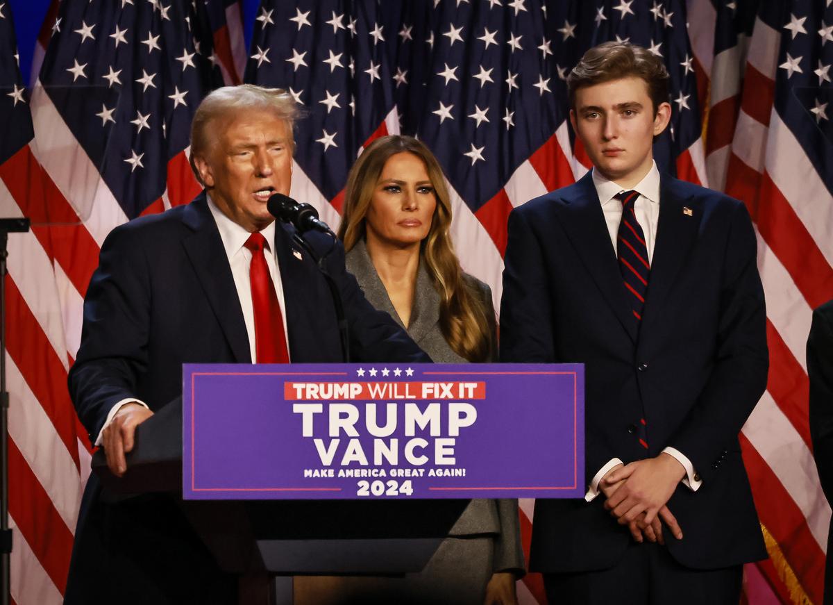 2024年11月6日，佛罗里达州西棕榈滩，川普在集会中自行宣布胜出总统大选，与妻子梅拉尼娅（Melania Trump，中）和小儿子巴伦（Barron Trump，右一）一起向支持者发表讲话。(John Fredricks／大纪元）