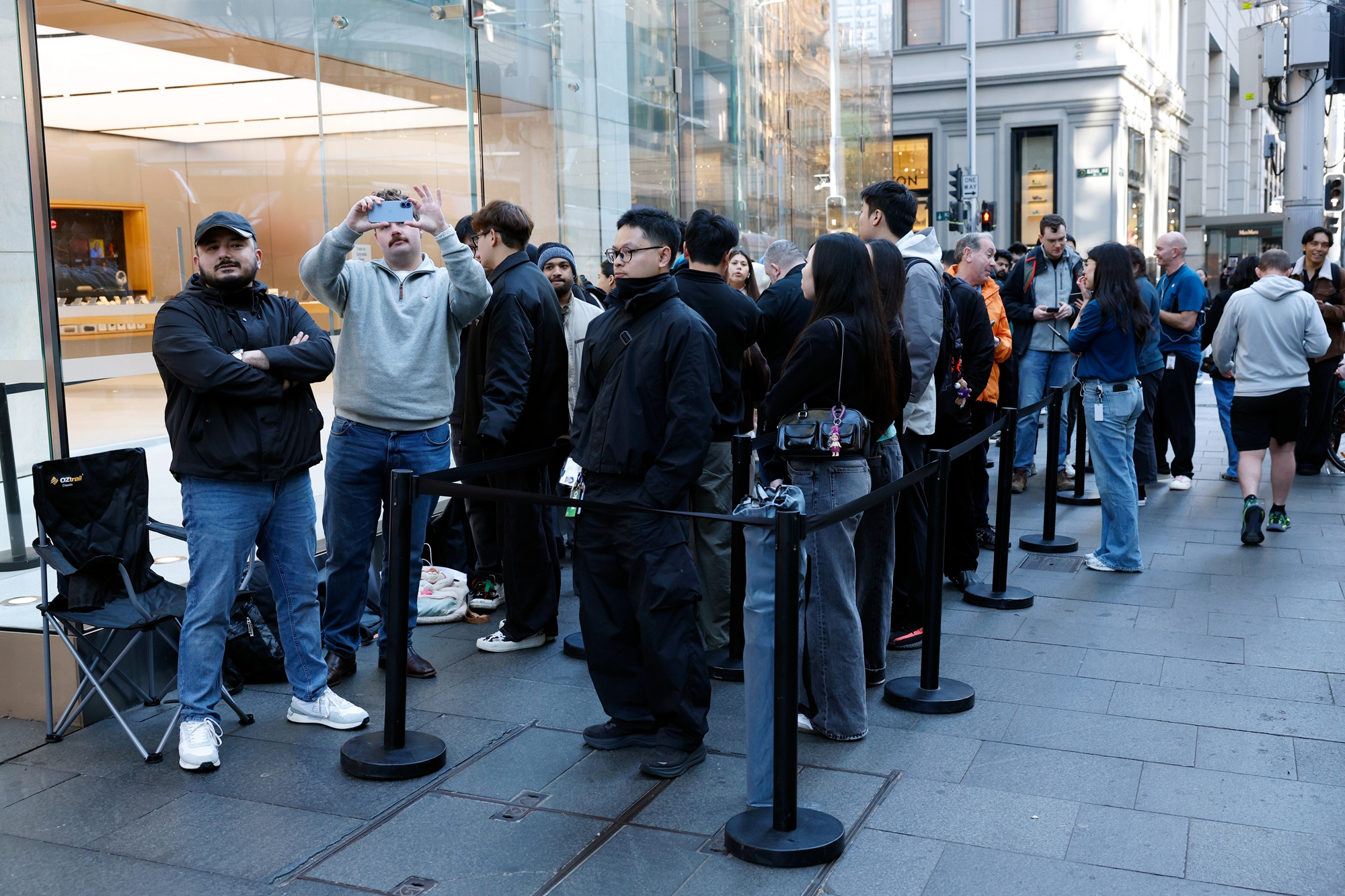 2026年9月18日,苹果新机iPhone 18 Pro与iPhone 18 Pro Max在位于悉尼中央商务区乔治街(George Street)的苹果专卖店正式开卖。图为提前订购的顾客在店外排队,等候购机。(Izhar Khan/Getty Images)
